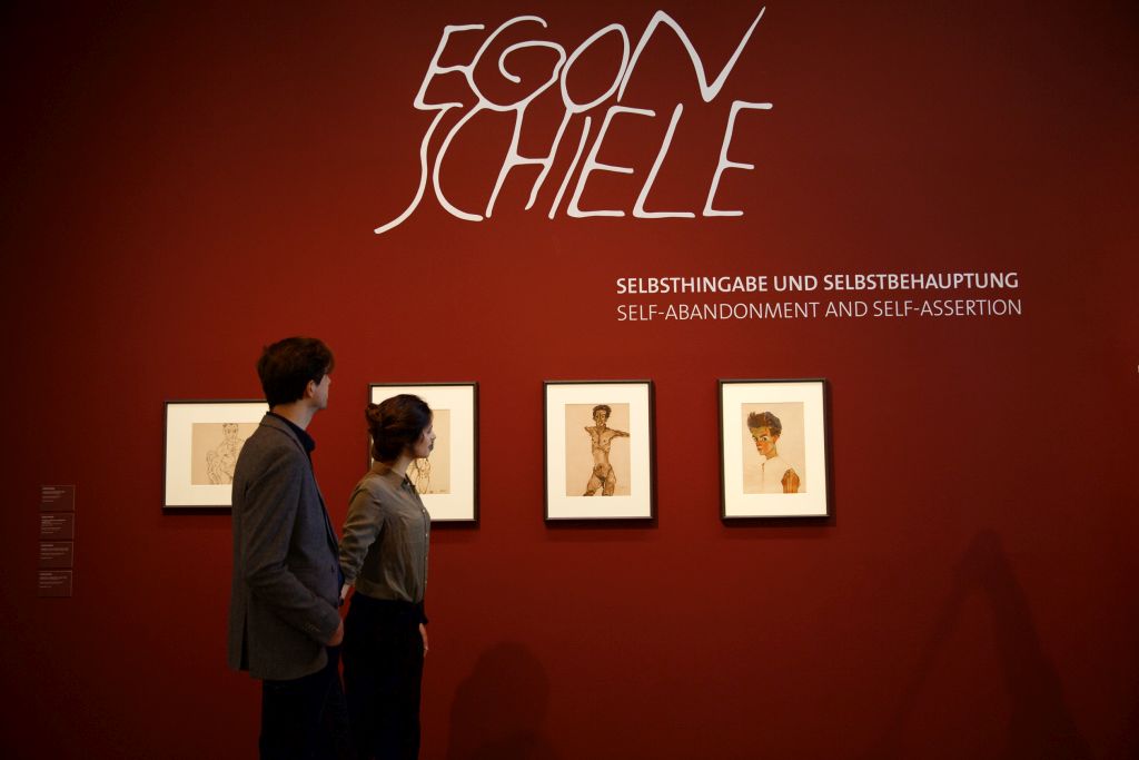 Two People standing in front of pictures of the Egon Schiele collection at the Leopold Museum in Vienna